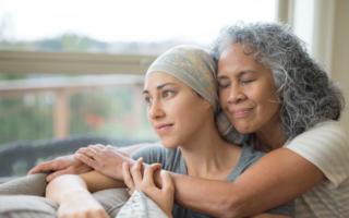 Mother embracing middle-aged daughter that has cancer